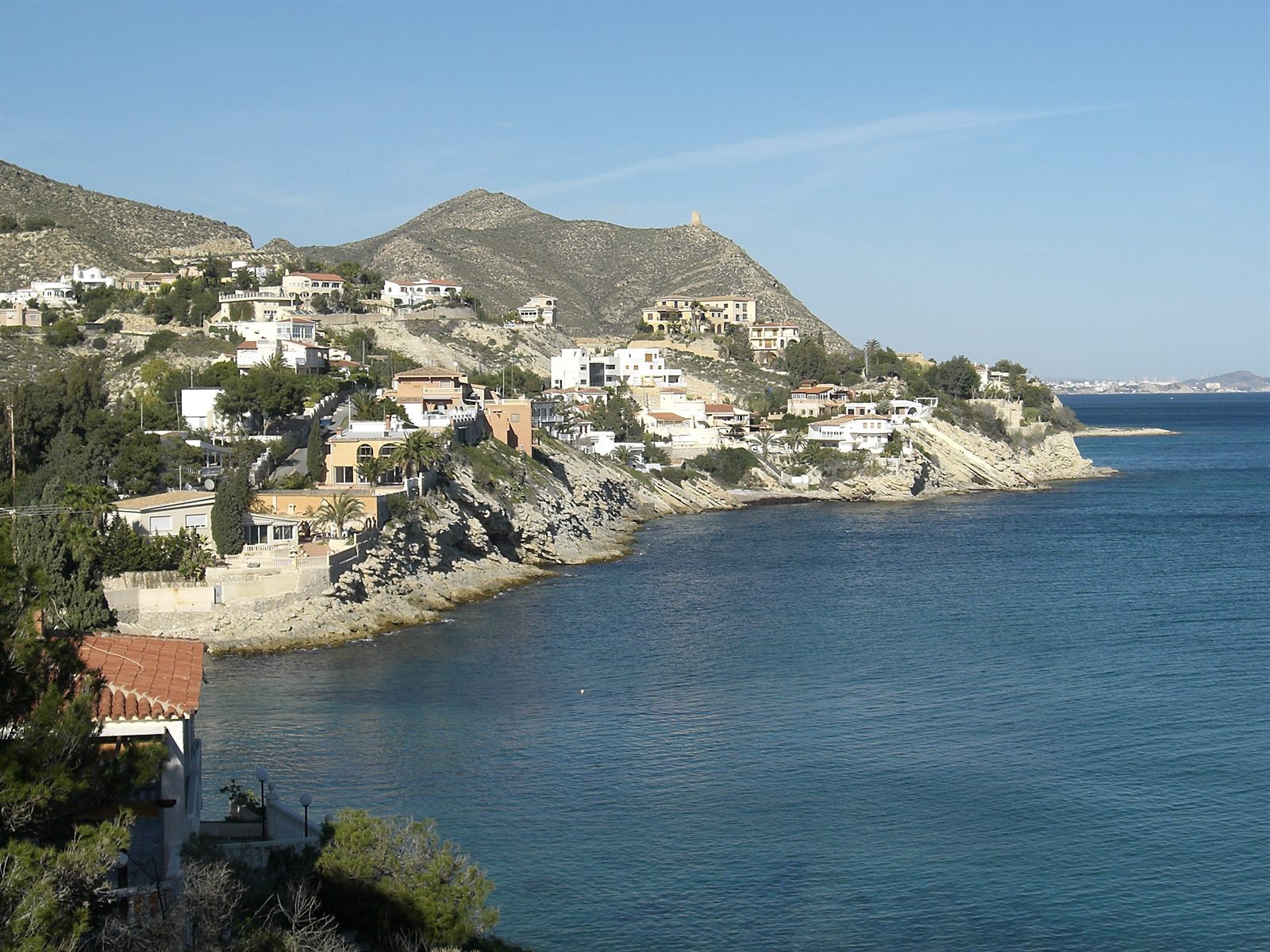 Küste von El Campello mit Wohnhäusern am Hang über dem Meer